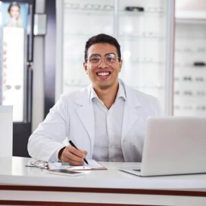 optometrist at desk with laptop