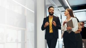 Two people waling through an office