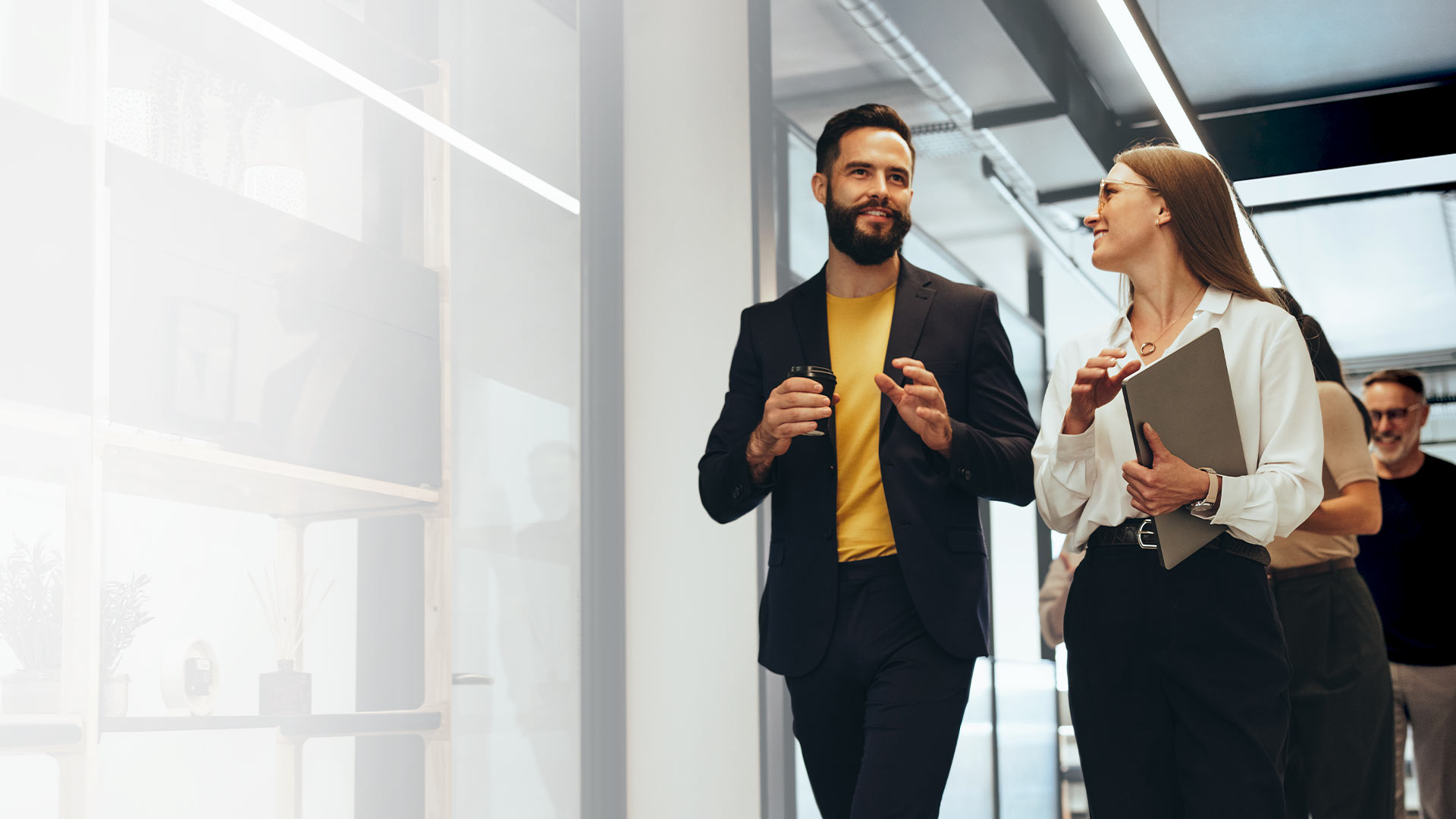 Two people waling through an office